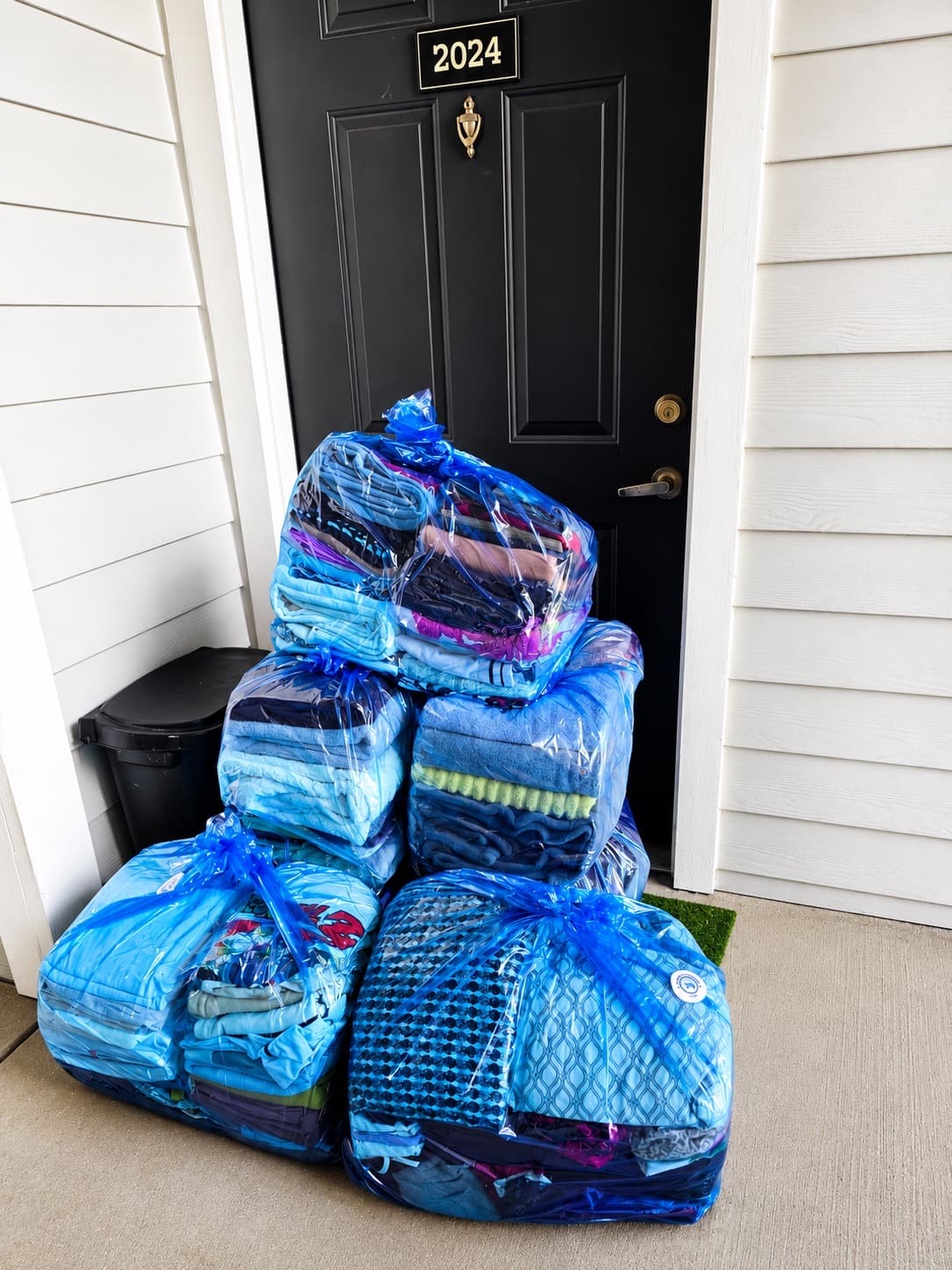 Stacked laundry bags ready for pickup at a customer's front door