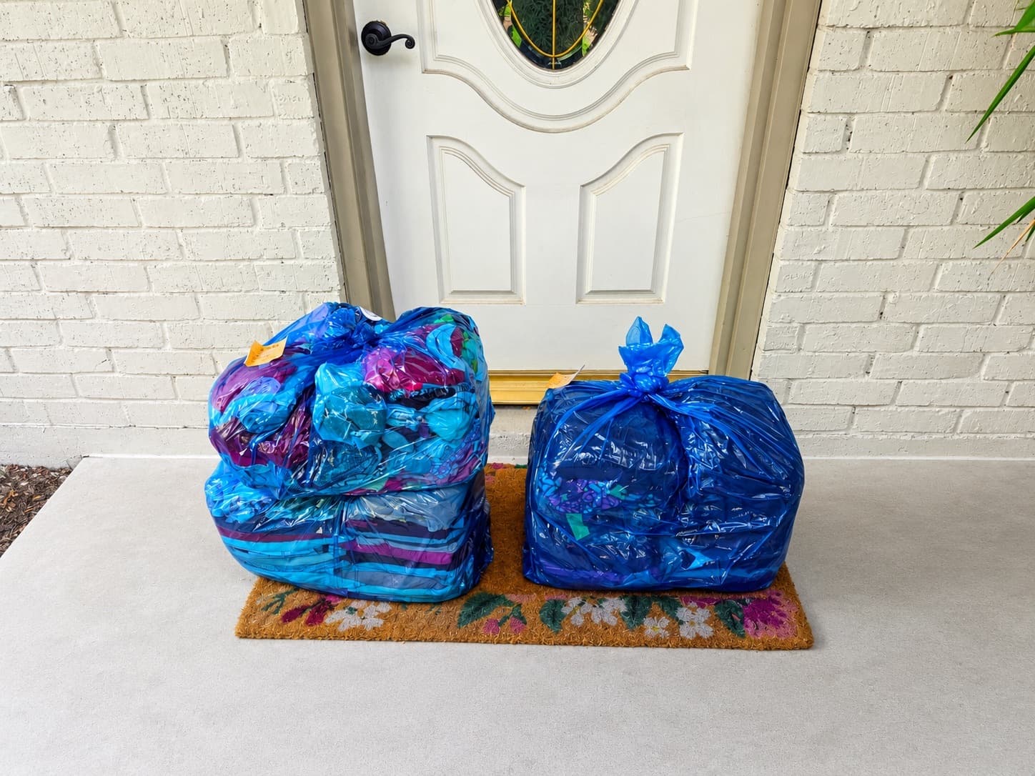 Two bags of laundry staged for pickup at a customer's front door