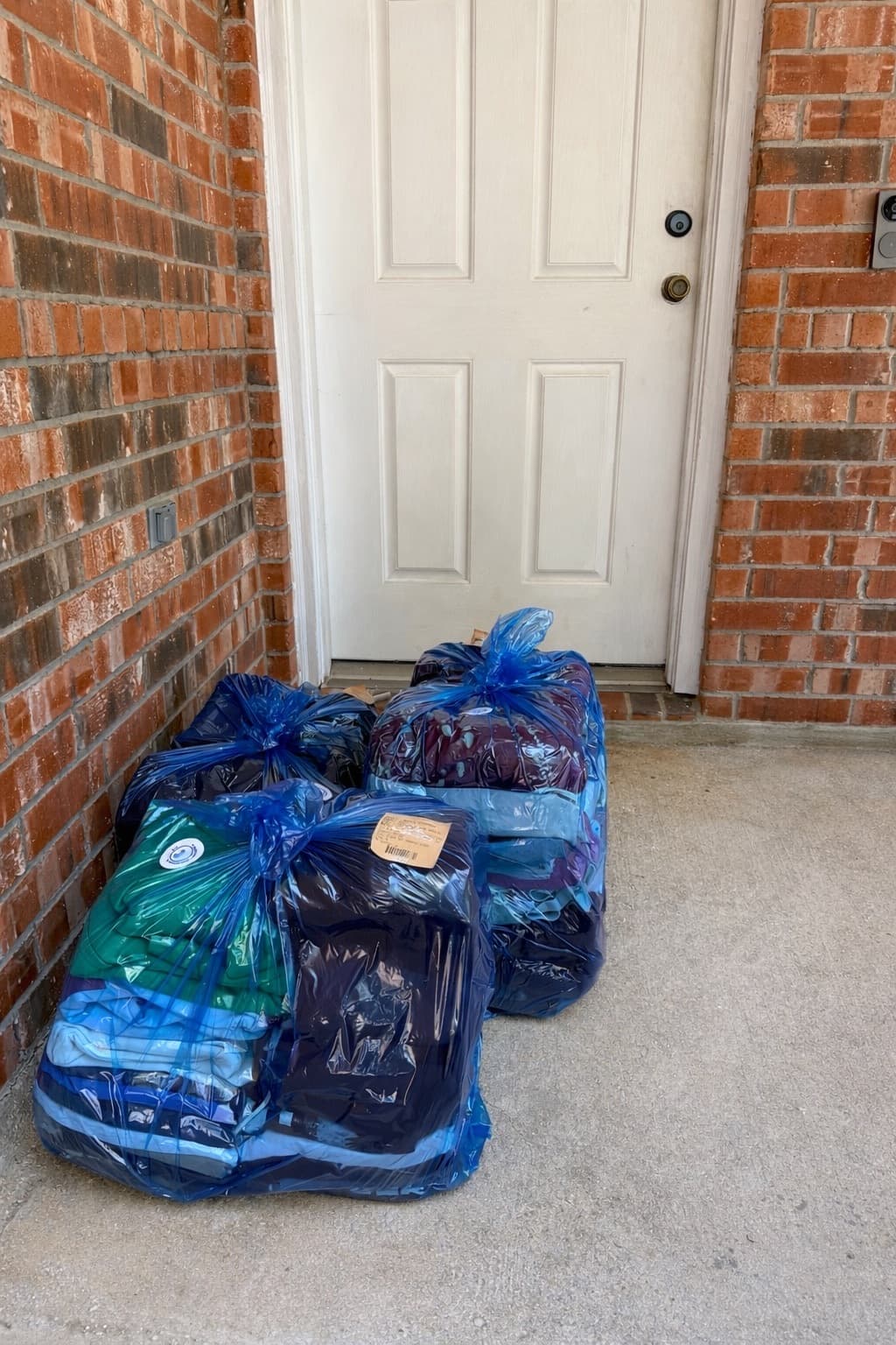 Bagged laundry stacked by the front door for pickup