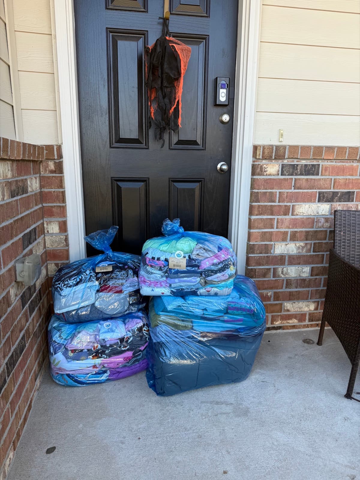 Bagged laundry staged for pickup near a front entryway