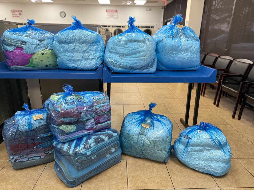 Eight finished wash & fold orders bagged and ready for customer pickup