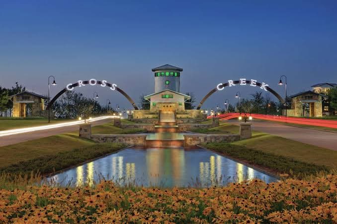 Cross Creek Ranch entrance arches and central tower lit up at dusk