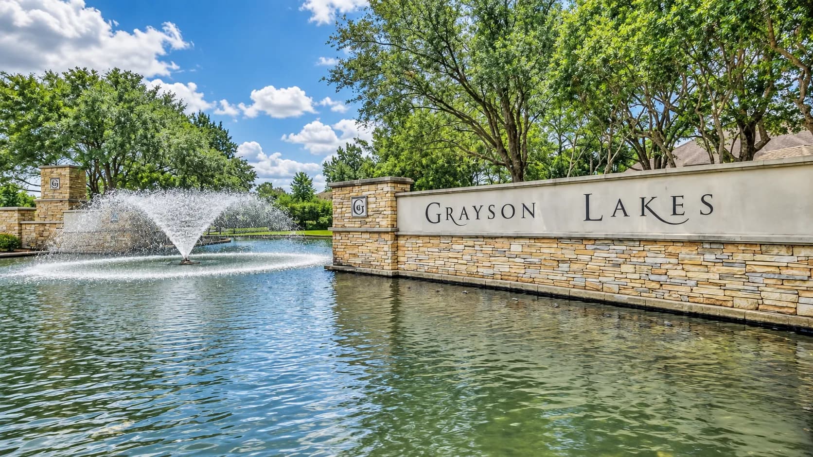 Grayson Lakes entrance monument sign beside a fountain on the community lake