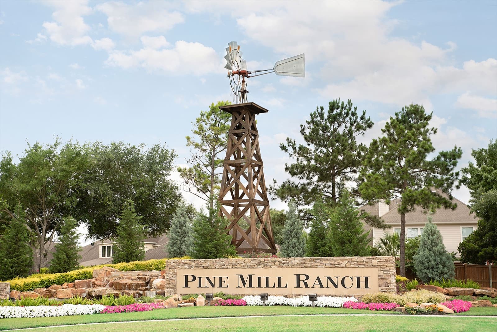 Pine Mill Ranch monument sign beneath a windmill landmark