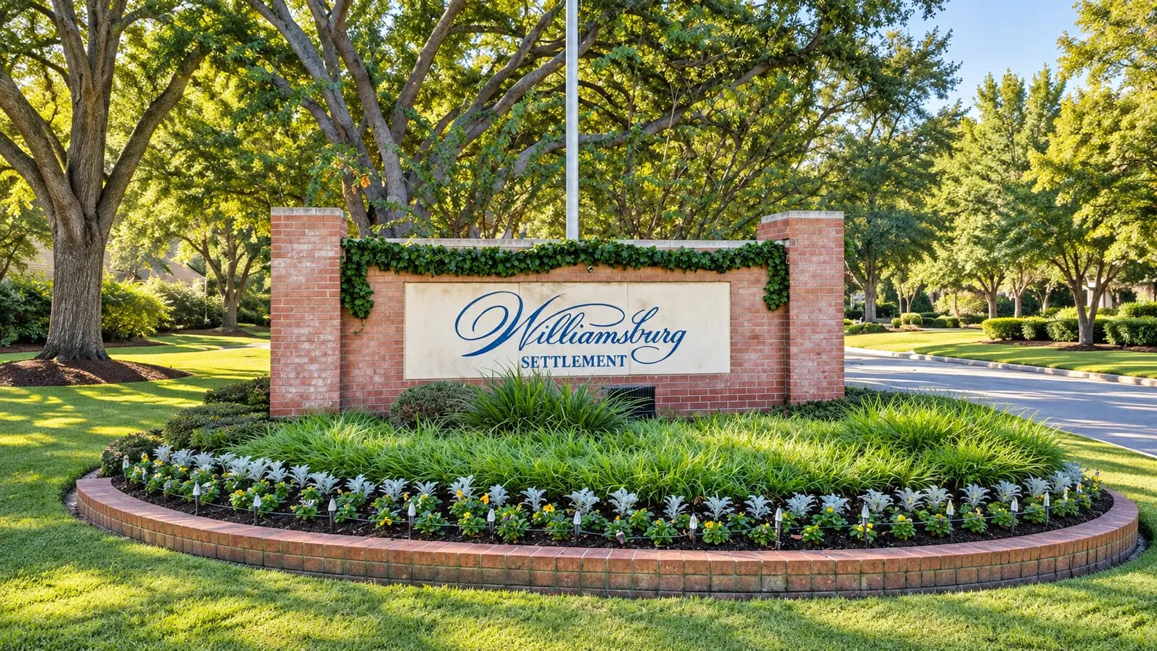 Williamsburg Settlement entrance monument sign beneath a canopy of mature oak trees