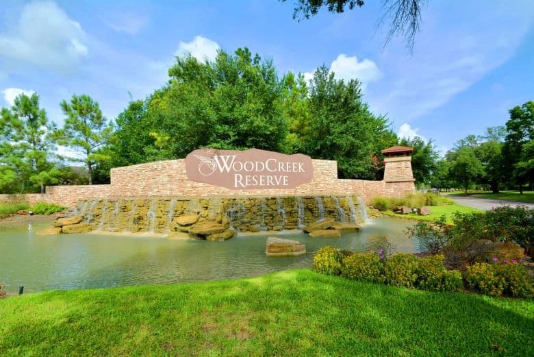 WoodCreek Reserve monument sign in front of a stone waterfall feature